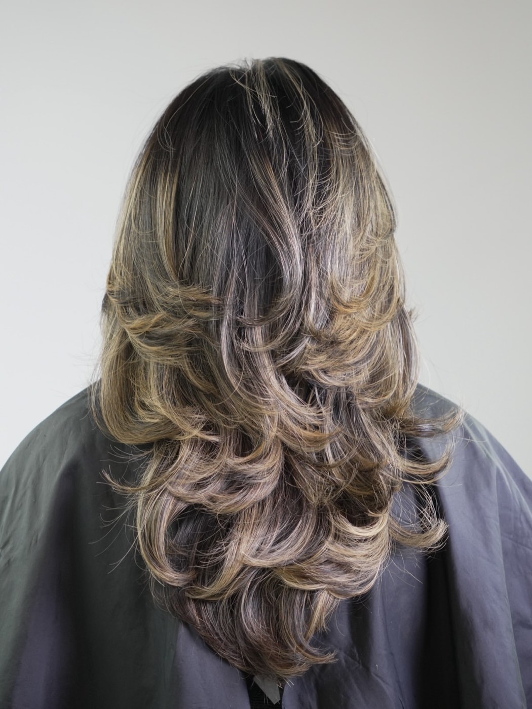 Hand-painted balayage with soft blonde layers, styled at Artistly