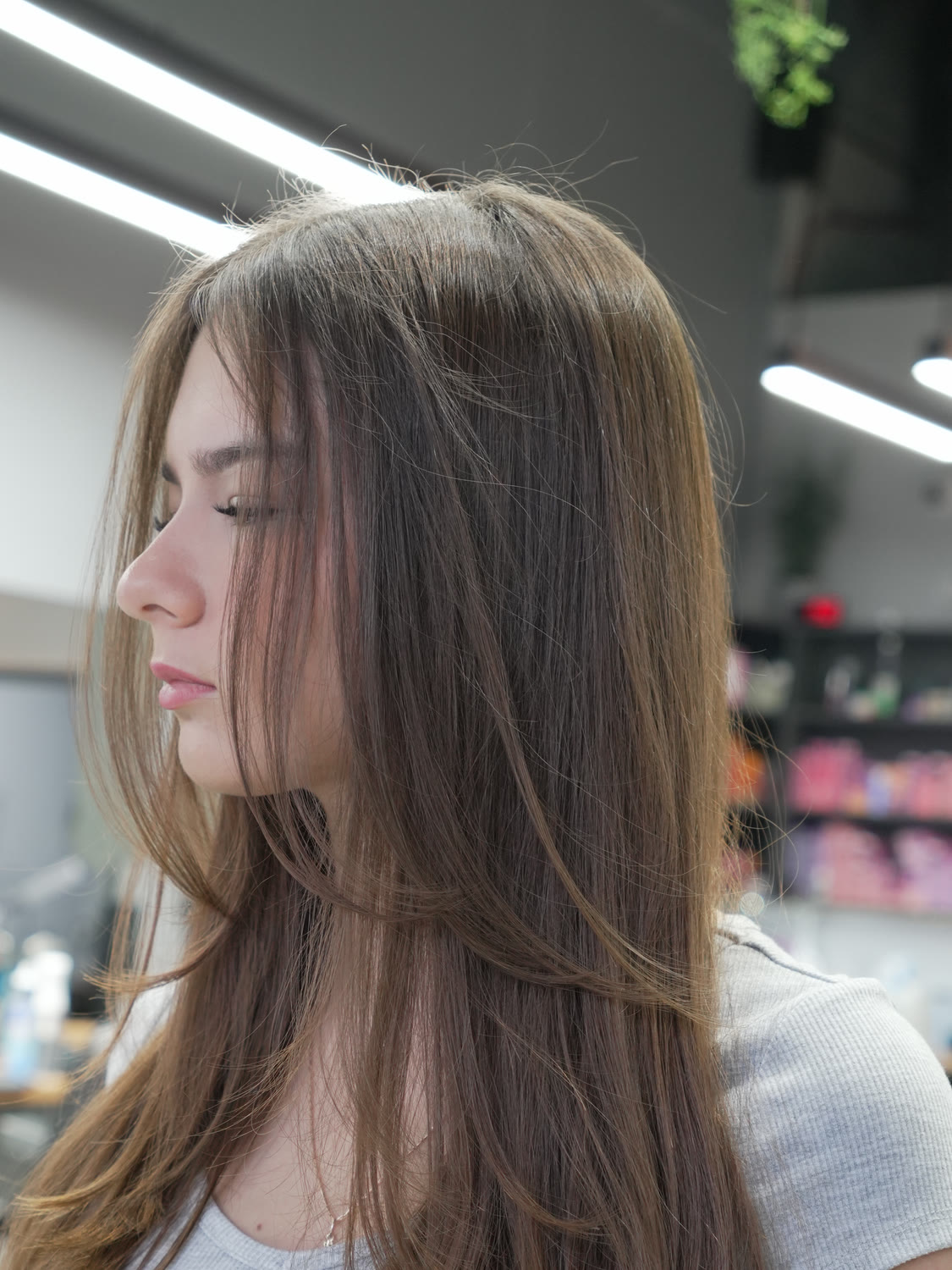 An Artistly stylist lifting a freshly finished blowout to check the shape